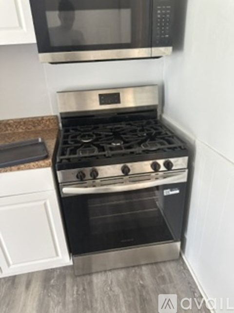A modern kitchen with a stainless steel oven and microwave above it.
