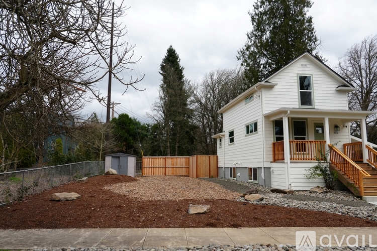 A white house with a brown fence and a brown roof.
