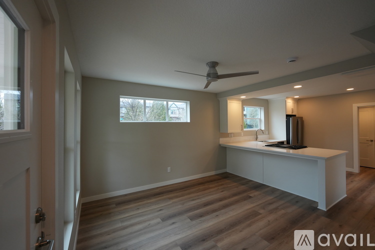 A spacious room with a ceiling fan and a countertop with a sink.