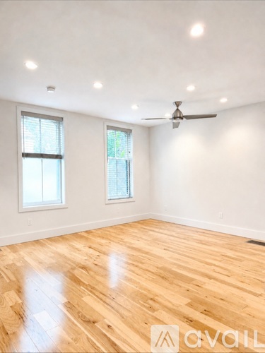 A room with wooden flooring and a ceiling fan.