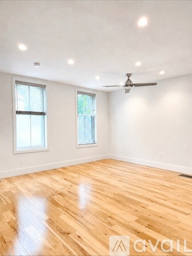 A room with wooden flooring and a ceiling fan.