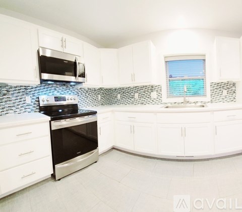 A kitchen with white cabinets and a black stove top oven.