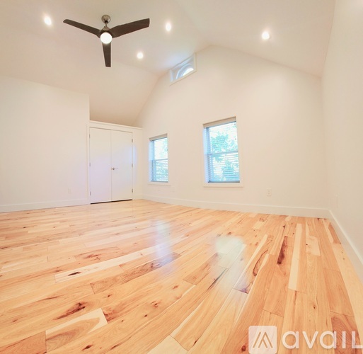 A room with wooden flooring and a ceiling fan.