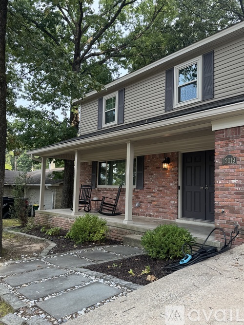 A house with a brick wall and a black door.
