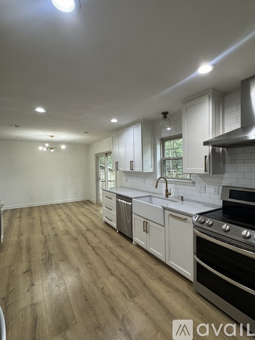 A kitchen with white cabinets and a black stove top oven.