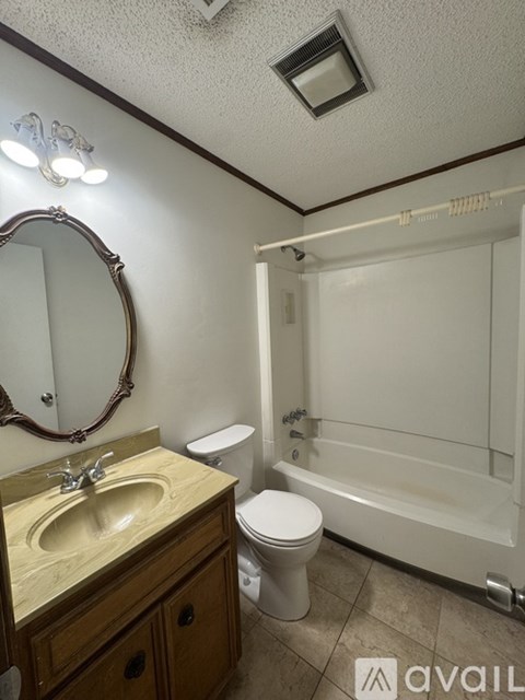 A bathroom with a sink, toilet, and bathtub.