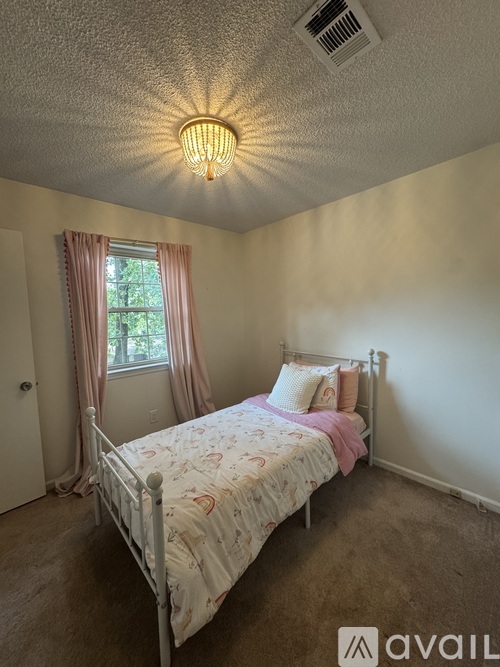 A bedroom with a bed, window, and a ceiling light.