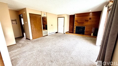 A living room with a carpeted floor and a television.