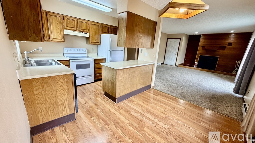 A kitchen with wooden cabinets and a white fridge.