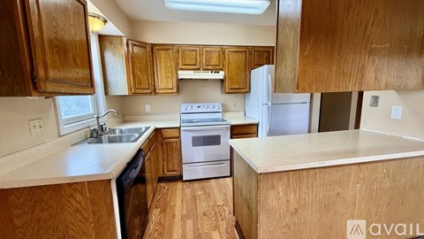 A kitchen with wooden cabinets and a white refrigerator.