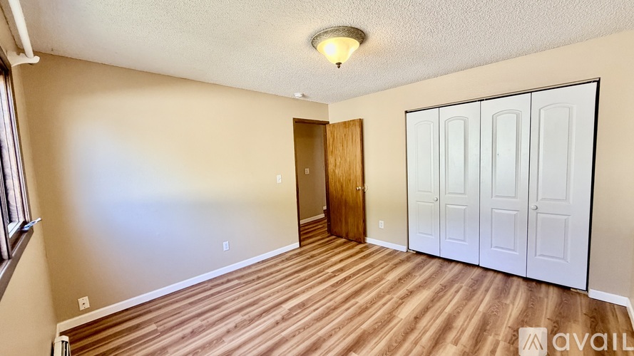 A room with wooden floors and a white door.