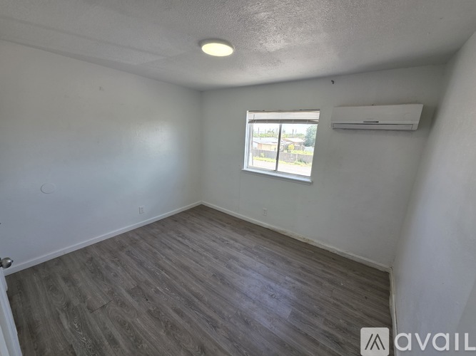 A room with a window and a wall-mounted air conditioner.
