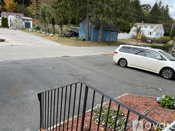 A white car is parked on the side of a road.