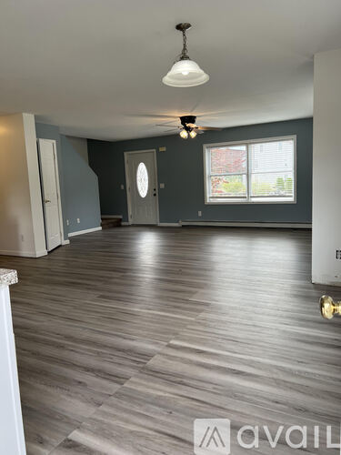 A room with wooden flooring and a ceiling fan.