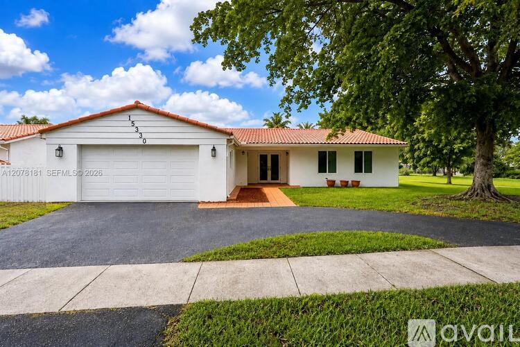 A house with a white garage door and a red roof.