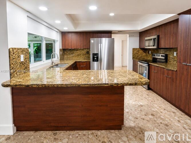 A kitchen with granite countertops and wooden cabinets is available for rent.