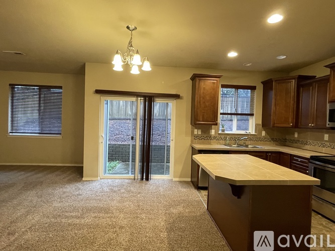 A kitchen with a wooden island and a dining area with a table and chairs.