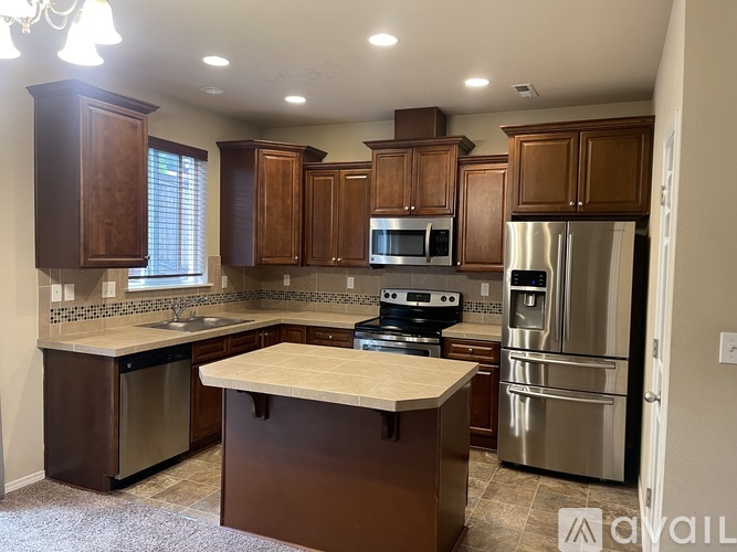 A kitchen with brown cabinets and stainless steel appliances.