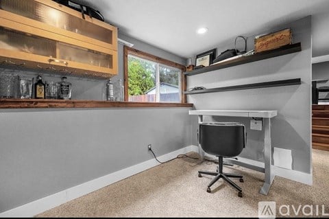 A room with a desk and a chair in it.
