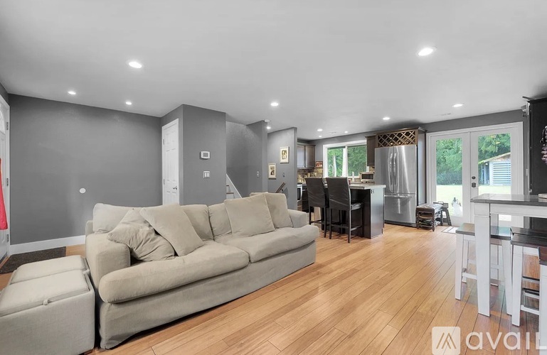A living room with a grey couch and wooden flooring.