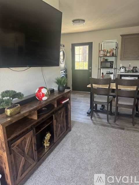 A living room with a flat screen TV mounted on the wall above a wooden entertainment center.
