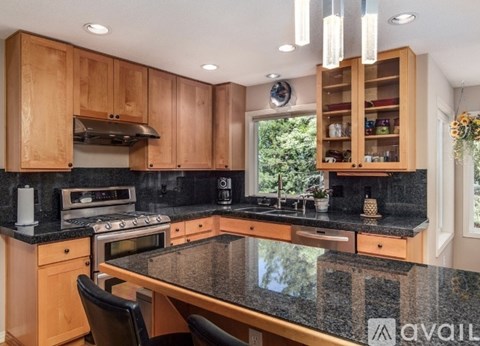 A kitchen with wooden cabinets and granite countertops.