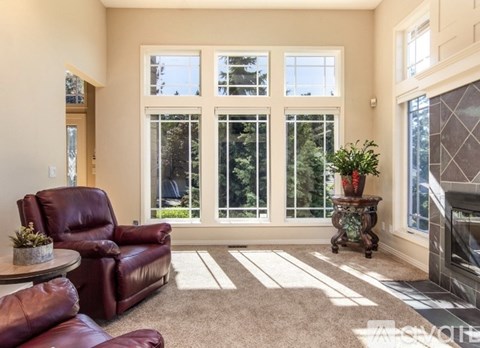 A living room with a red leather chair and a glass door.