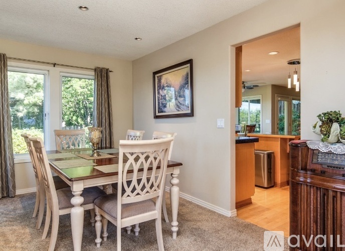 A dining room with a wooden table and chairs.