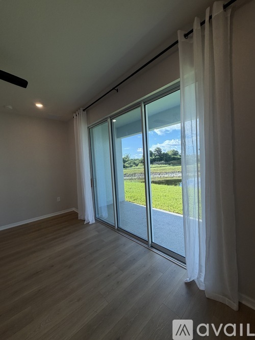 A room with a sliding glass door leading to a grassy area.