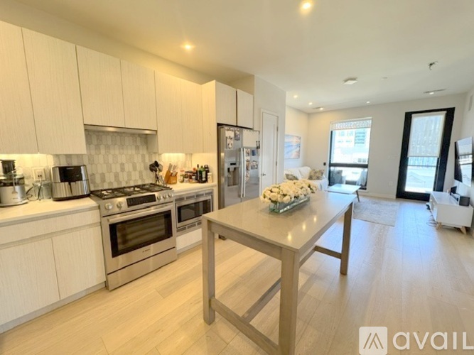 A modern kitchen with a dining table and chairs in the foreground.