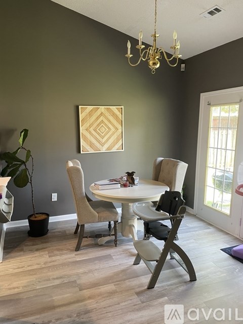 A dining room with a white table and chairs.