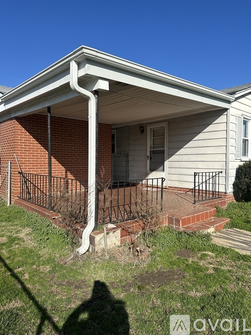 A house with a white porch and a black railing.