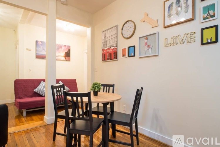 A dining room with a red couch, a white table, and a wall with pictures and a word LOVE.