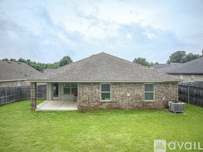 A house with a brick exterior and a large lawn in front.