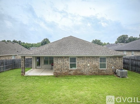 A house with a brick exterior and a large lawn in front.