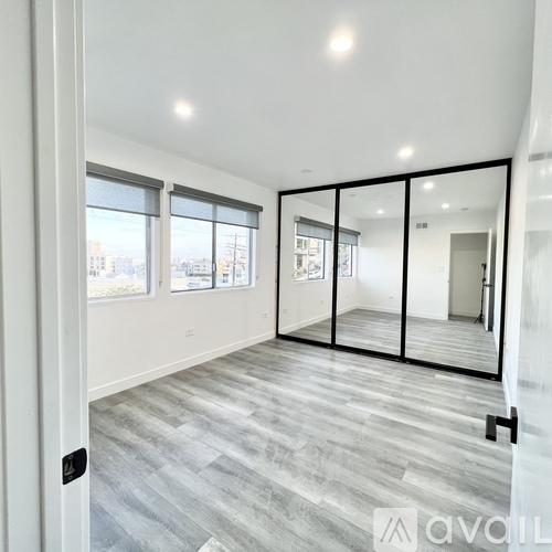 A spacious room with a view of the city through the windows.