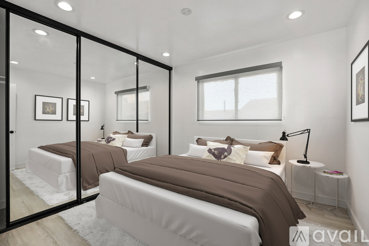 A bedroom with two beds and a large mirror.