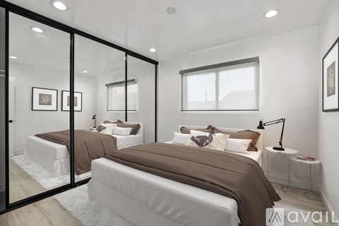 A bedroom with two beds and a large mirror.