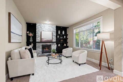A living room with a fireplace and a painting on the wall.