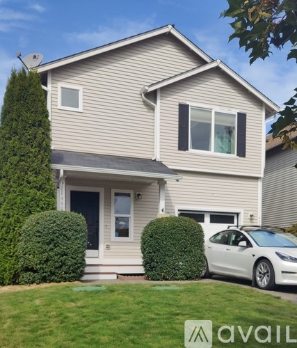 A house with a white car parked in front.