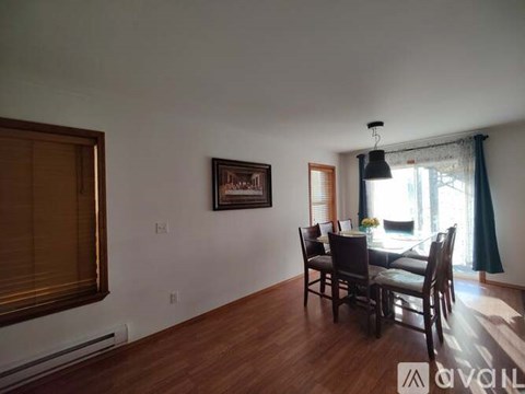 A dining room with a wooden table and chairs.
