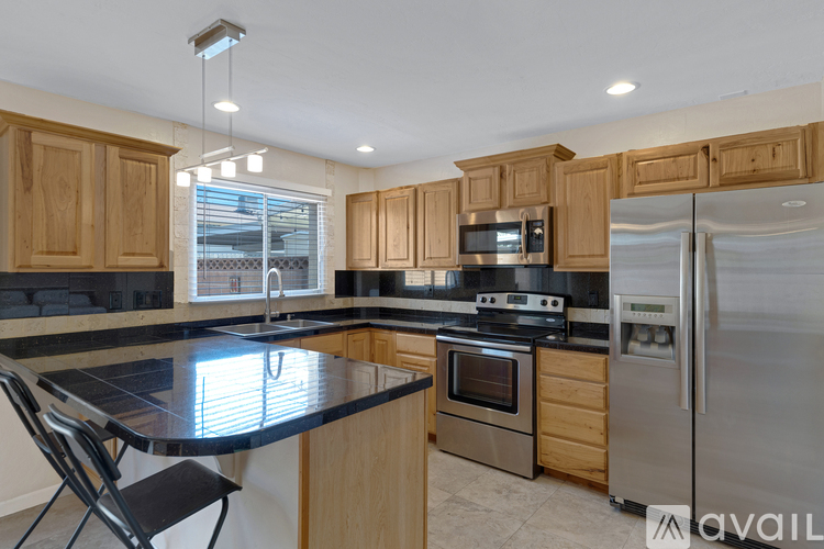 A kitchen with wooden cabinets and a black countertop.