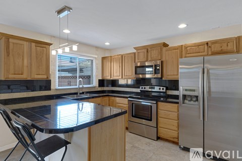A kitchen with wooden cabinets and a black countertop.
