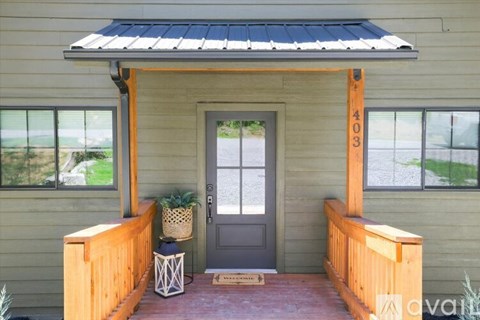 A wooden house with a black door and a window.