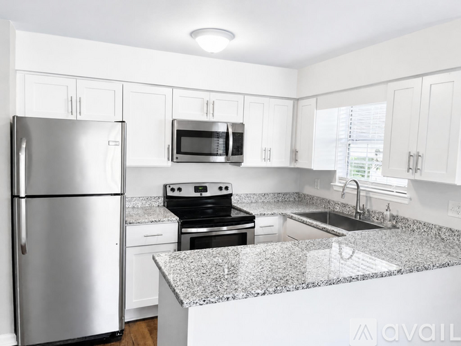 A kitchen with a stainless steel refrigerator, microwave, oven, and sink.