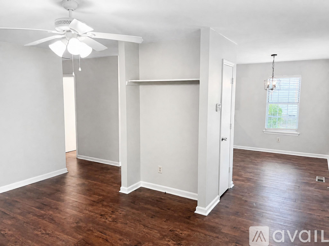 A room with a ceiling fan and a window with blinds.