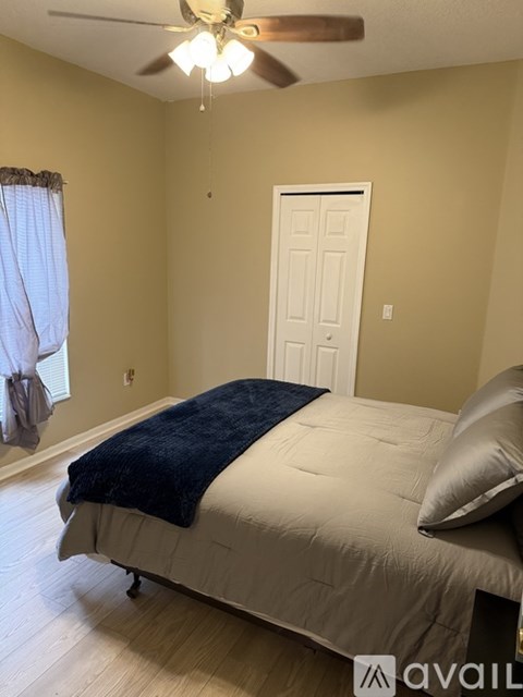 A bedroom with a bed, pillow, and a ceiling fan.