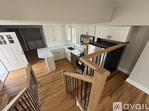 A kitchen with white cabinets and a wooden floor.
