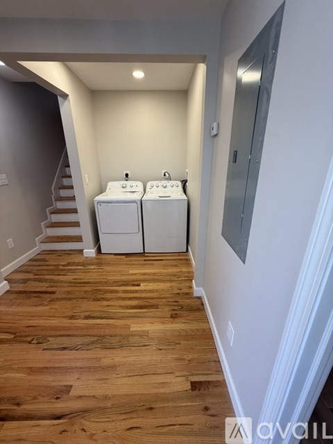 A hallway with two washing machines in the corner.