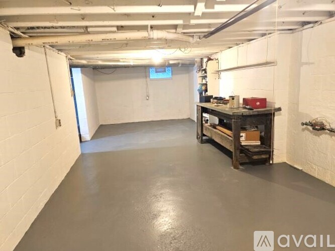 A spacious, empty room with a workbench and tools.